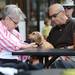 Mary Alman reaches over to her pooch Casey as her husband sits by while the pair listen to the Fortytwo perform during the AnnArbor.com Summer Concert series on Friday afternoon. Melanie Maxwell I AnnArbor.com